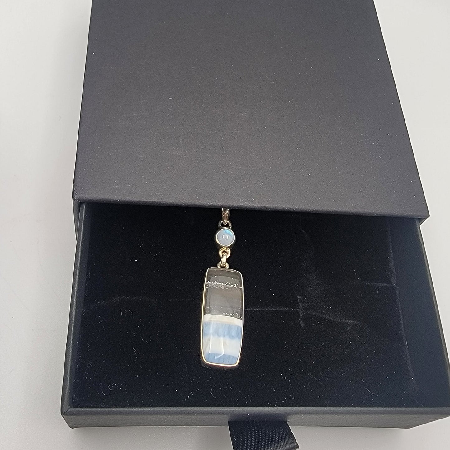 Jewelry box with an opal and silver necklace on a white background