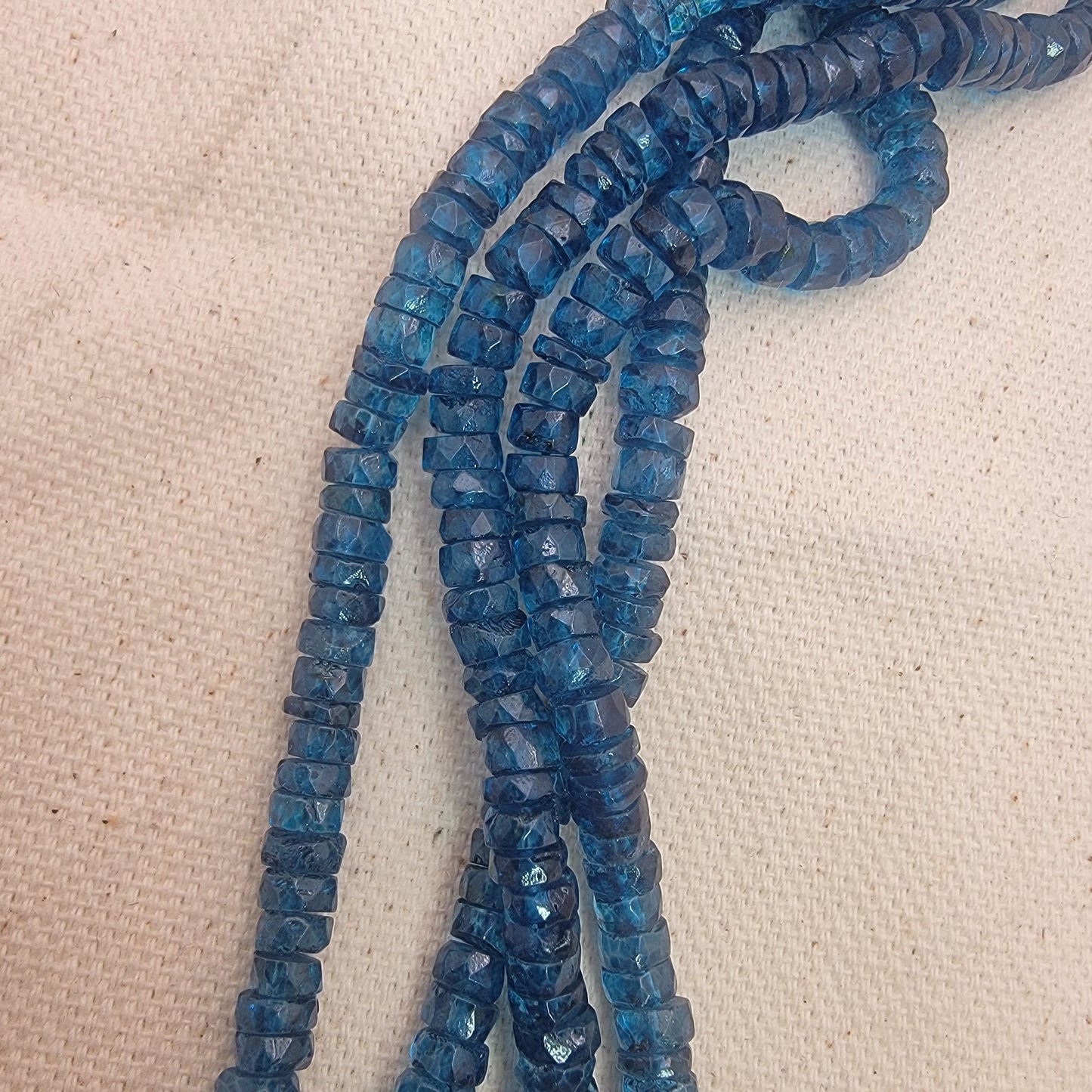blue topaz bead strands on neutral background