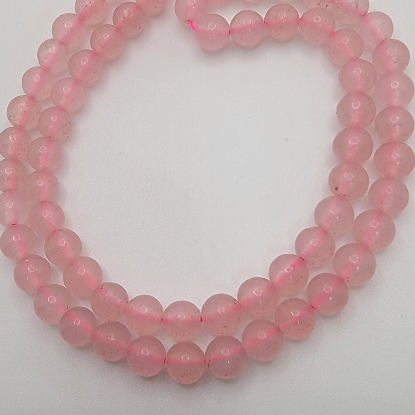 Pink bead strands on a white background