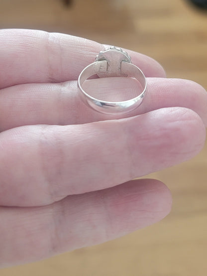 Back view of Pink Tourmaline and Sterling silver ring with bead detail around the bezel being held in a hand