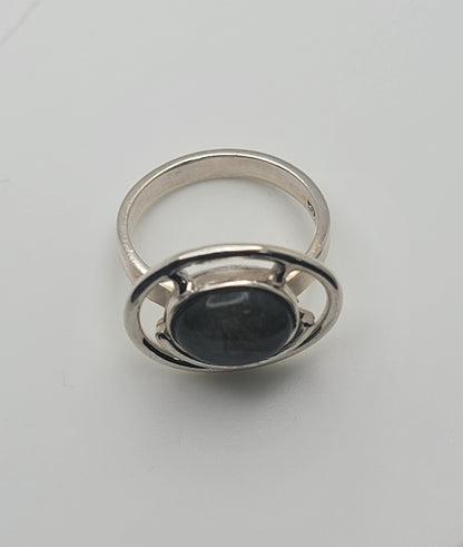 Close-up view of the Labradorite Ring 925 Sterling Silver Statement Ring resting on a white background. This piece is a must-have for anyone looking for casual jewelry, making it a thoughtful Gift for Her or Gift for Him. The ring stands out as a beautiful statement ring in polished Sterling Silver.