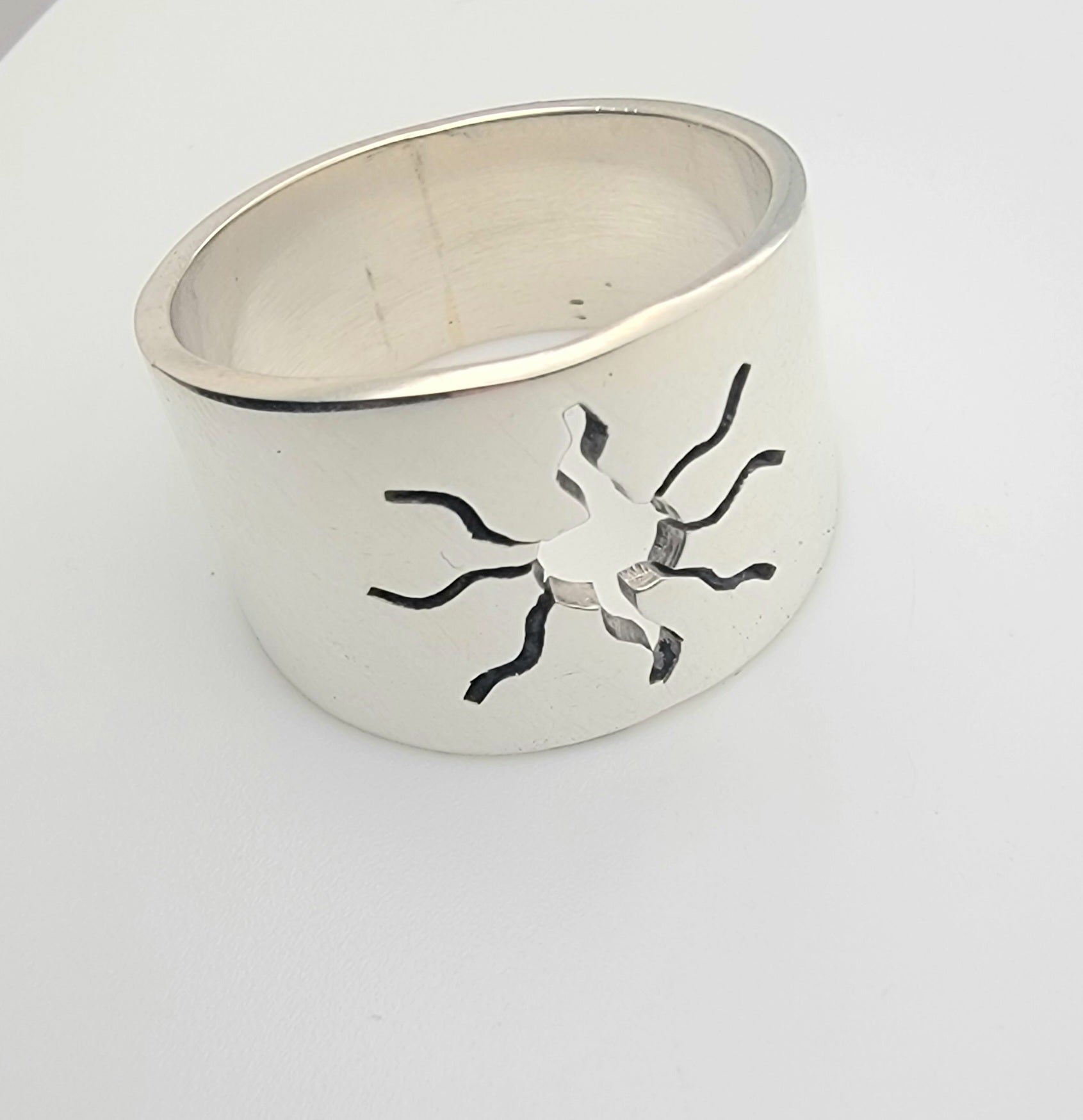 Side view of the 925 Sterling Silver Wideband Sunburst Ring, highlighting its unique sun cutout design. A lightweight statement ring, it perfectly blends with everyday casual jewelry and adds a celestial vibe to your accessory collection.