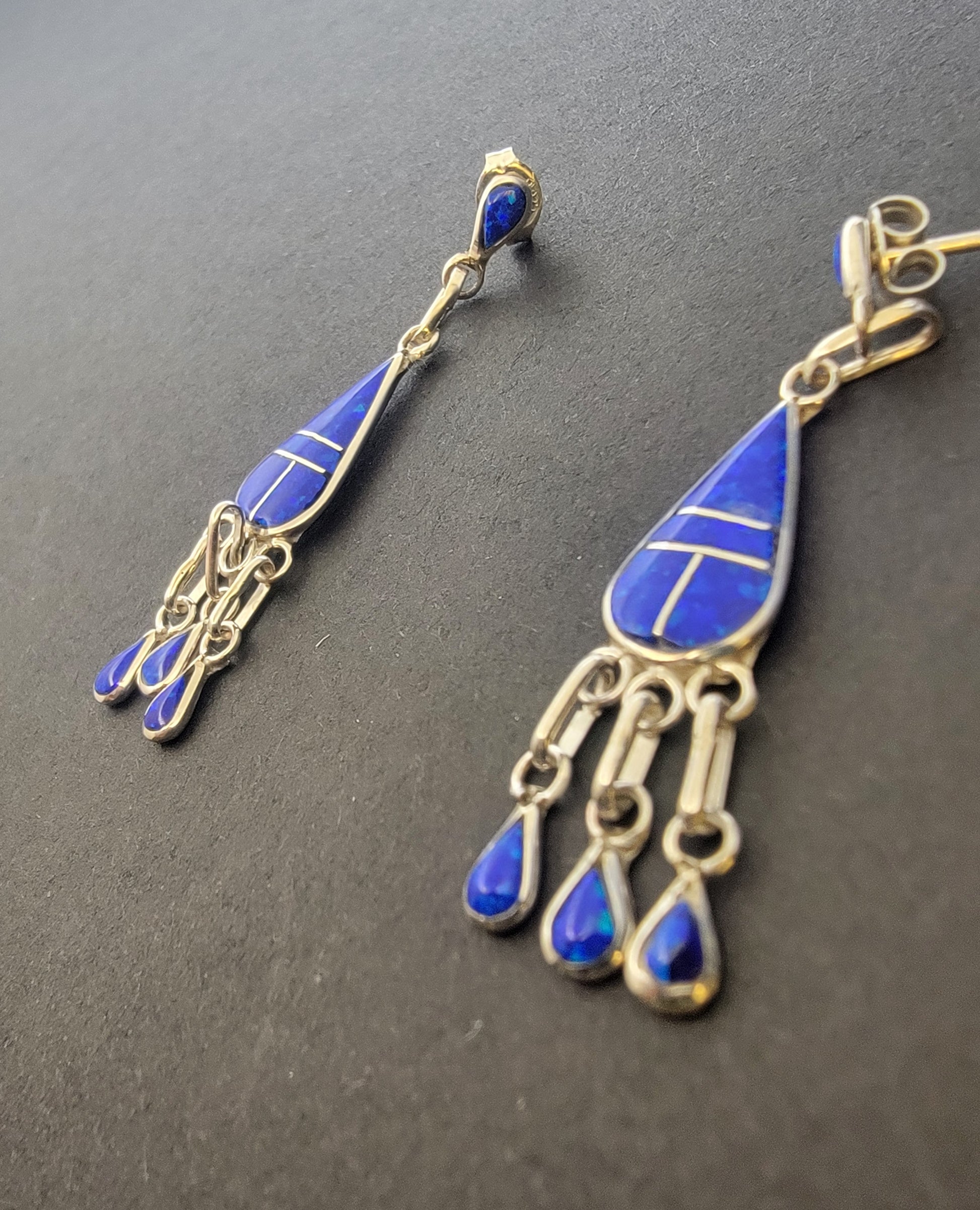 Close-up view of handcrafted opal inlay dangle earrings highlighting intricate craftsmanship and vibrant colors.