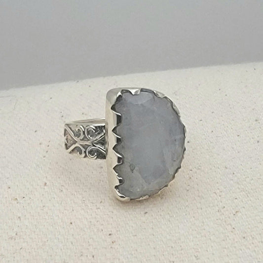 Size 8.5 sterling silver ring featuring a 10×15 mm half-moon moonstone set in a scalloped bezel on a tapered band.