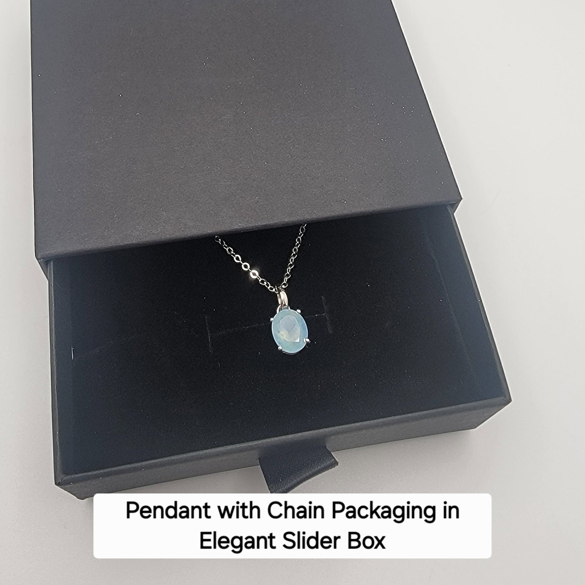 Faceted Aquamrine Pendant with sterling silver chain in an elegant black slider box on a white background