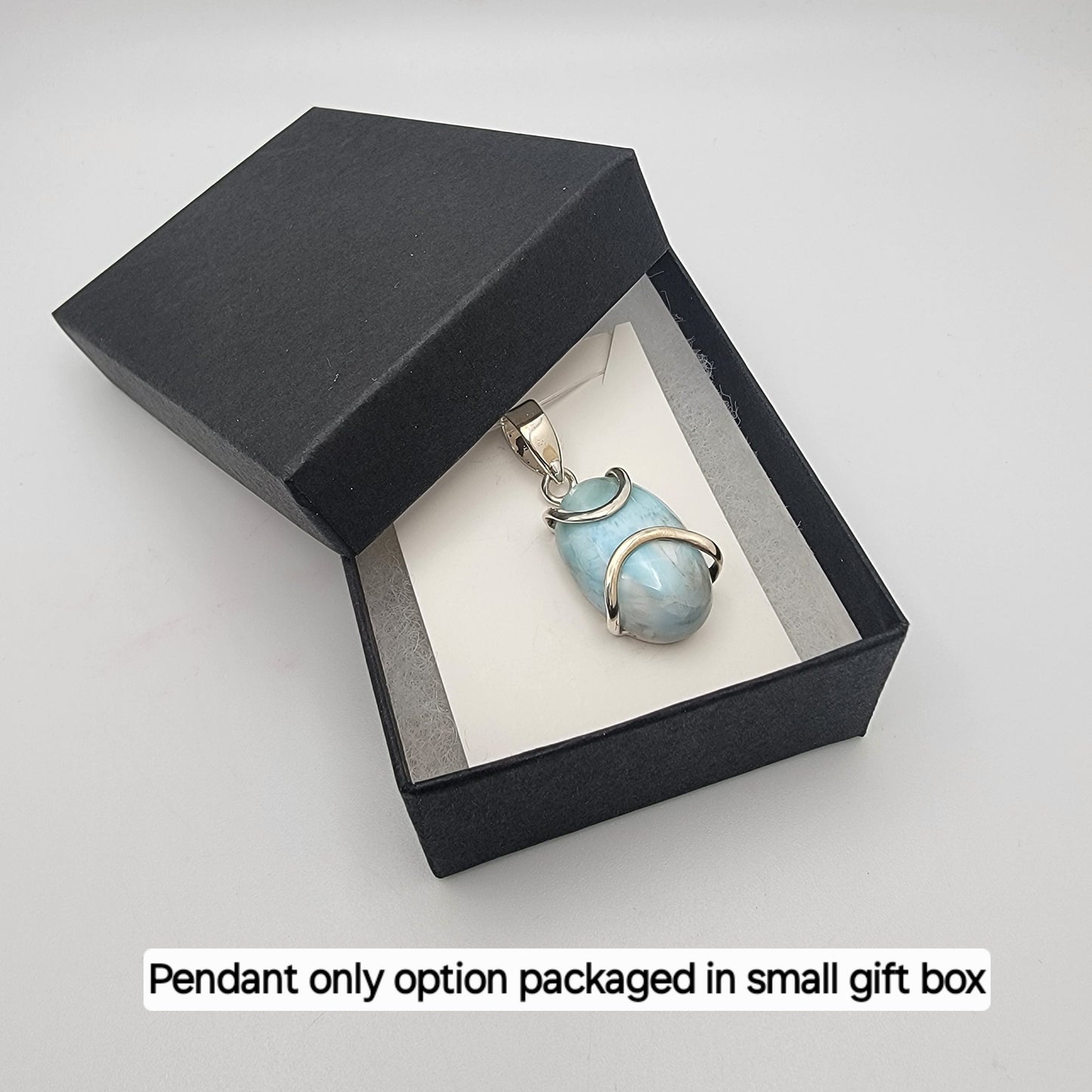 Pendant in a small gift box on a light gray background