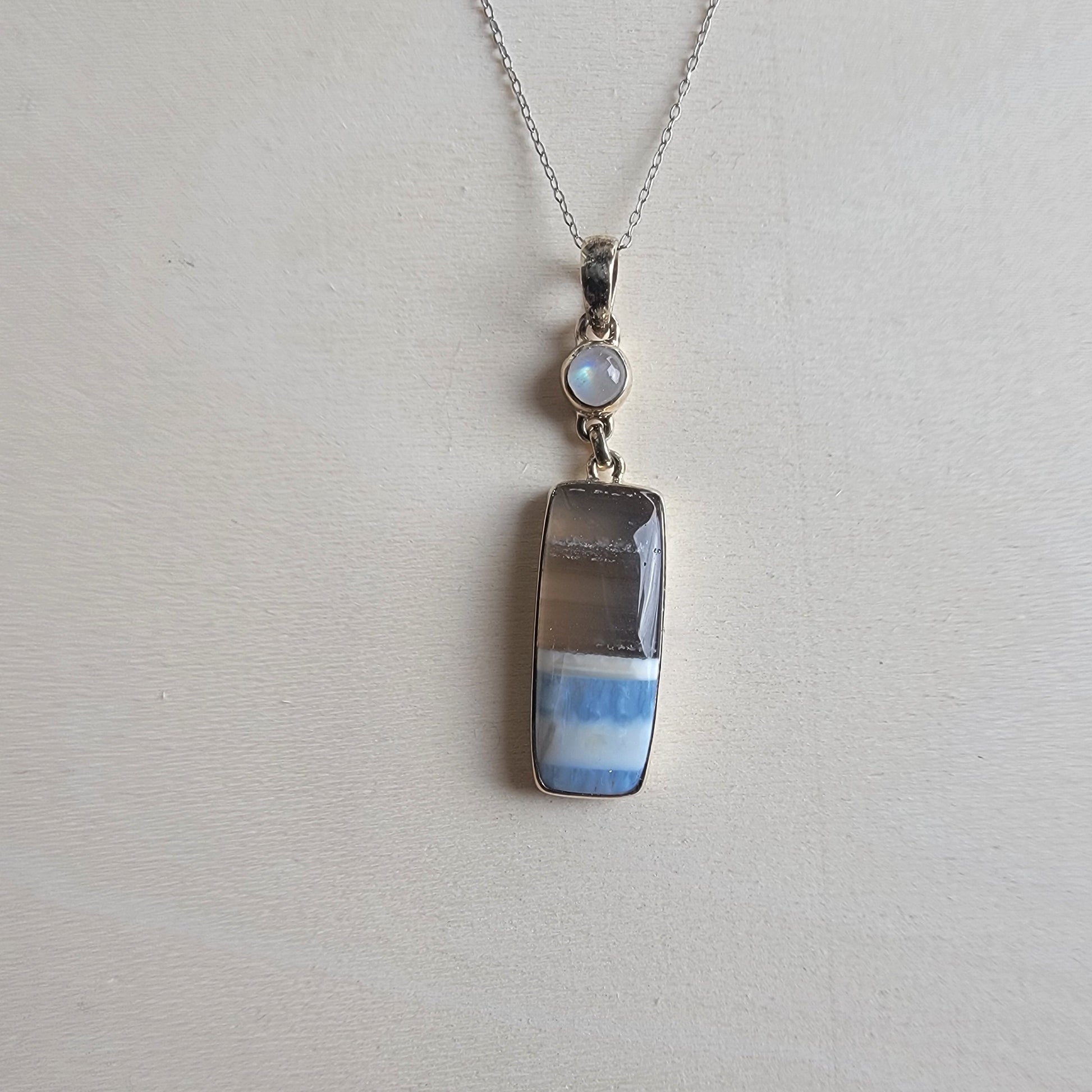 Blue Opal and moonstone necklace with a pendant on a light gray background