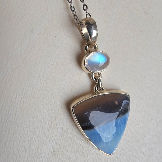 Necklace with a blue opal pendant on a light gray background