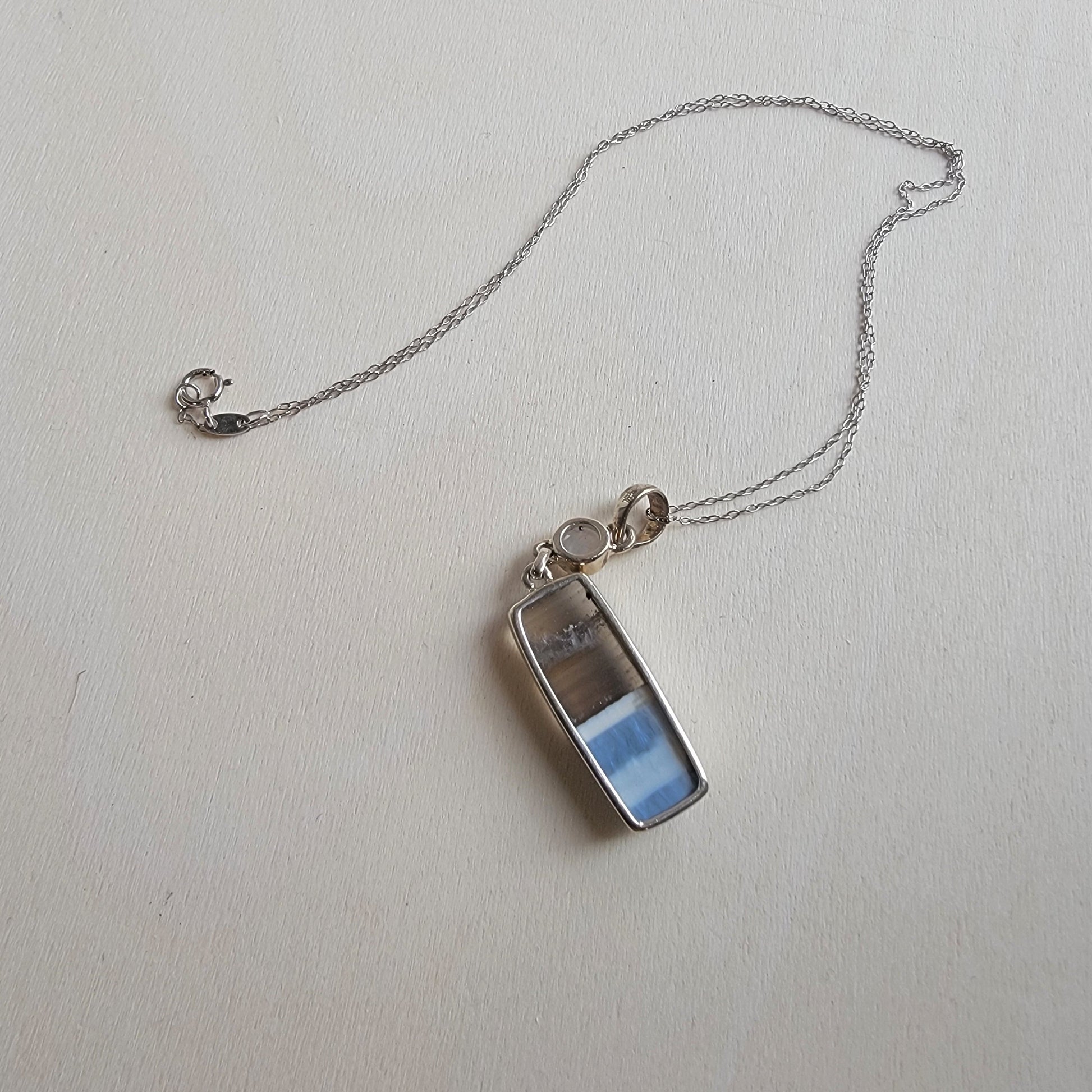 Small electronic device with a chain on a light gray background