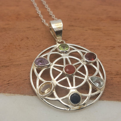 Silver pendant with gemstones on a wooden surface