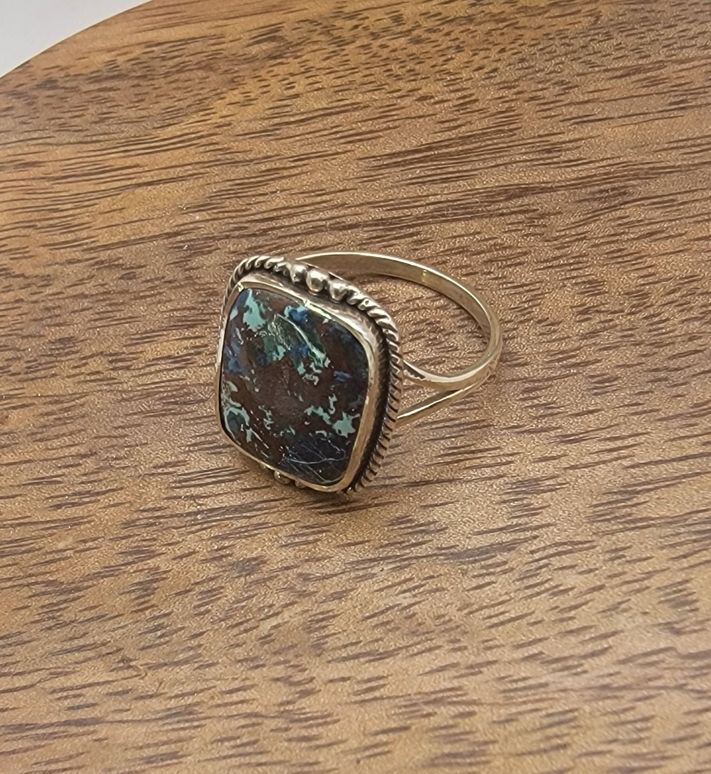 Silver ing with a gemstone on a wooden surface