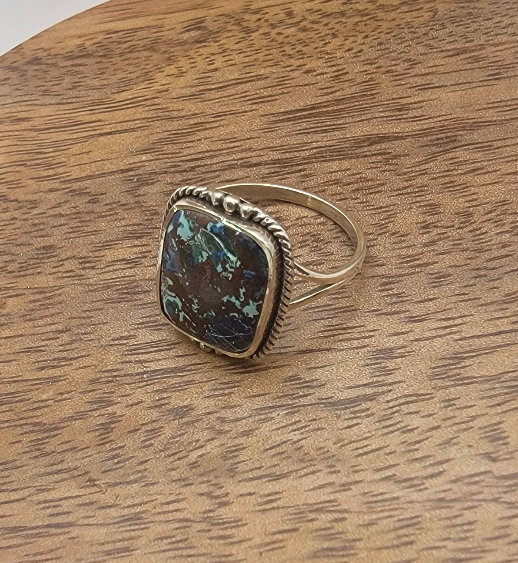 Silver ing with a gemstone on a wooden surface