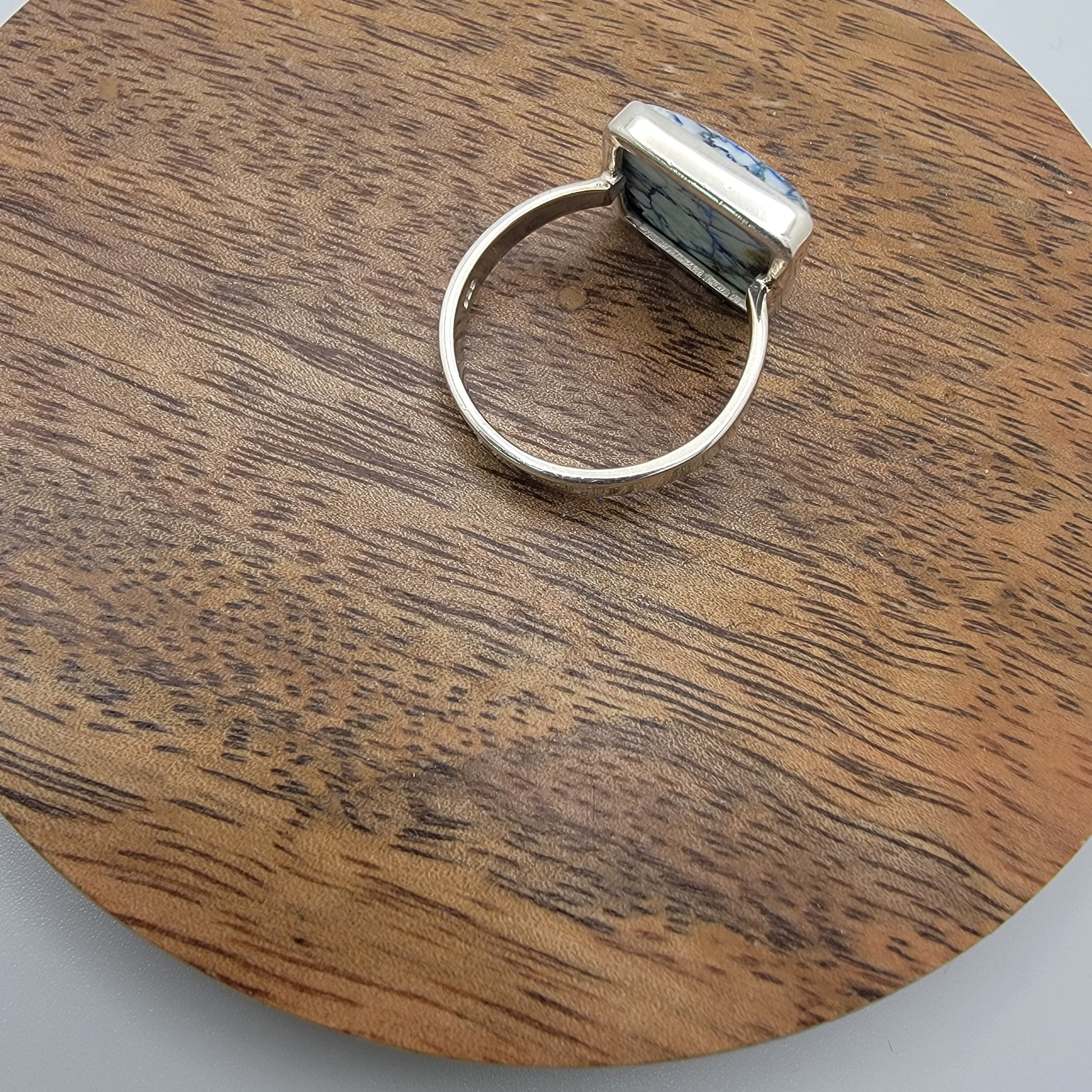 Silver ring on a wooden circular platform