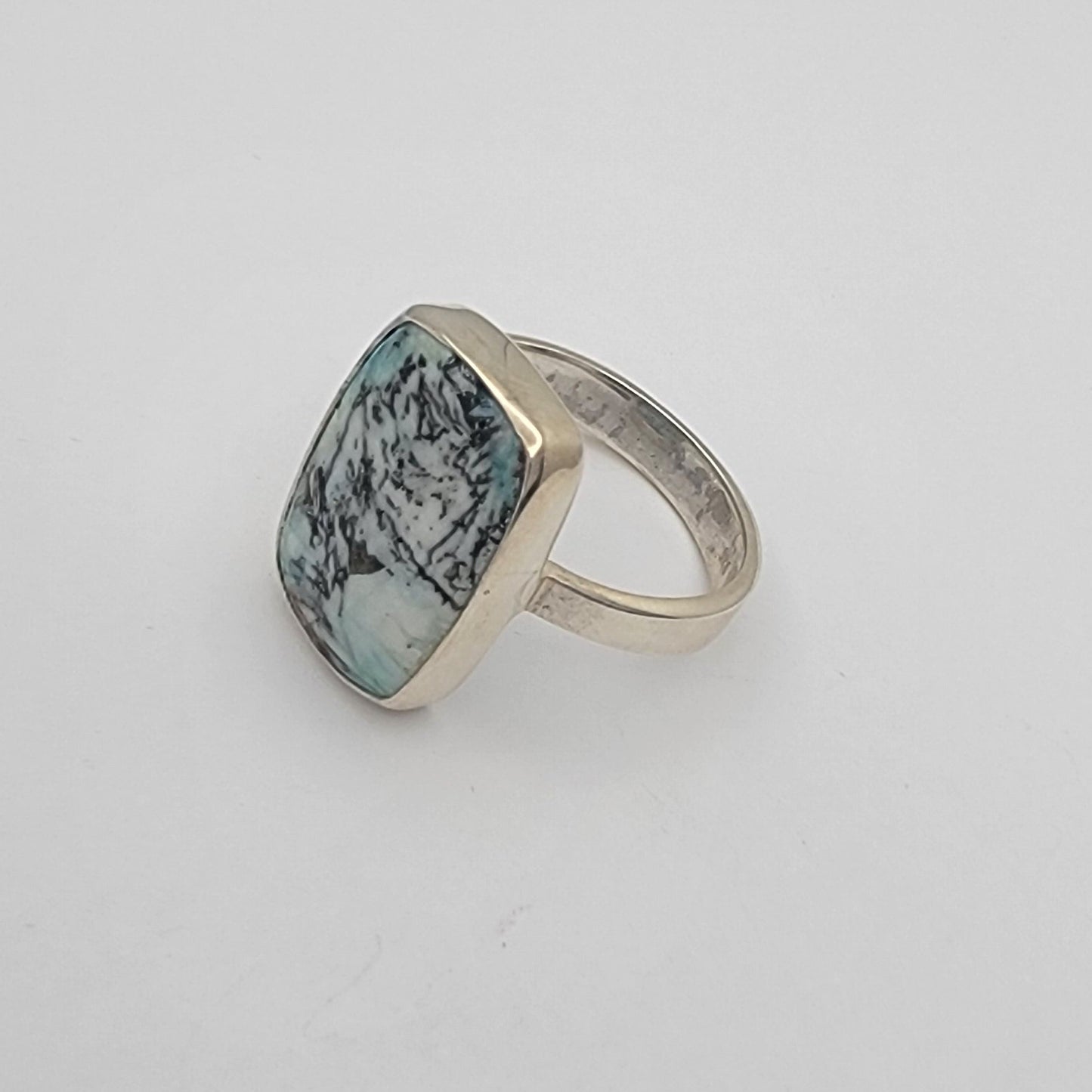 Ring with a green gemstone on a white surface