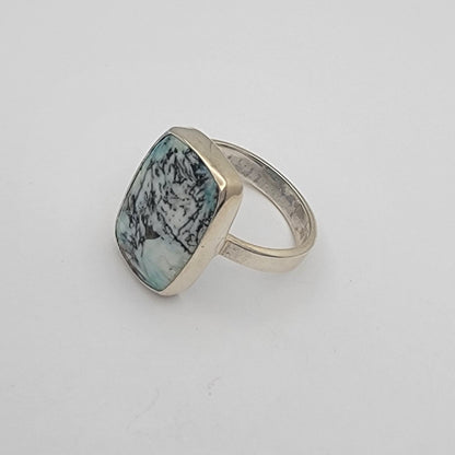 Ring with a green gemstone on a white surface