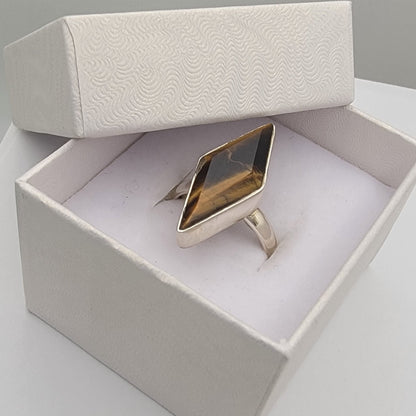 Sterling silver ring in a white box on a light gray surface