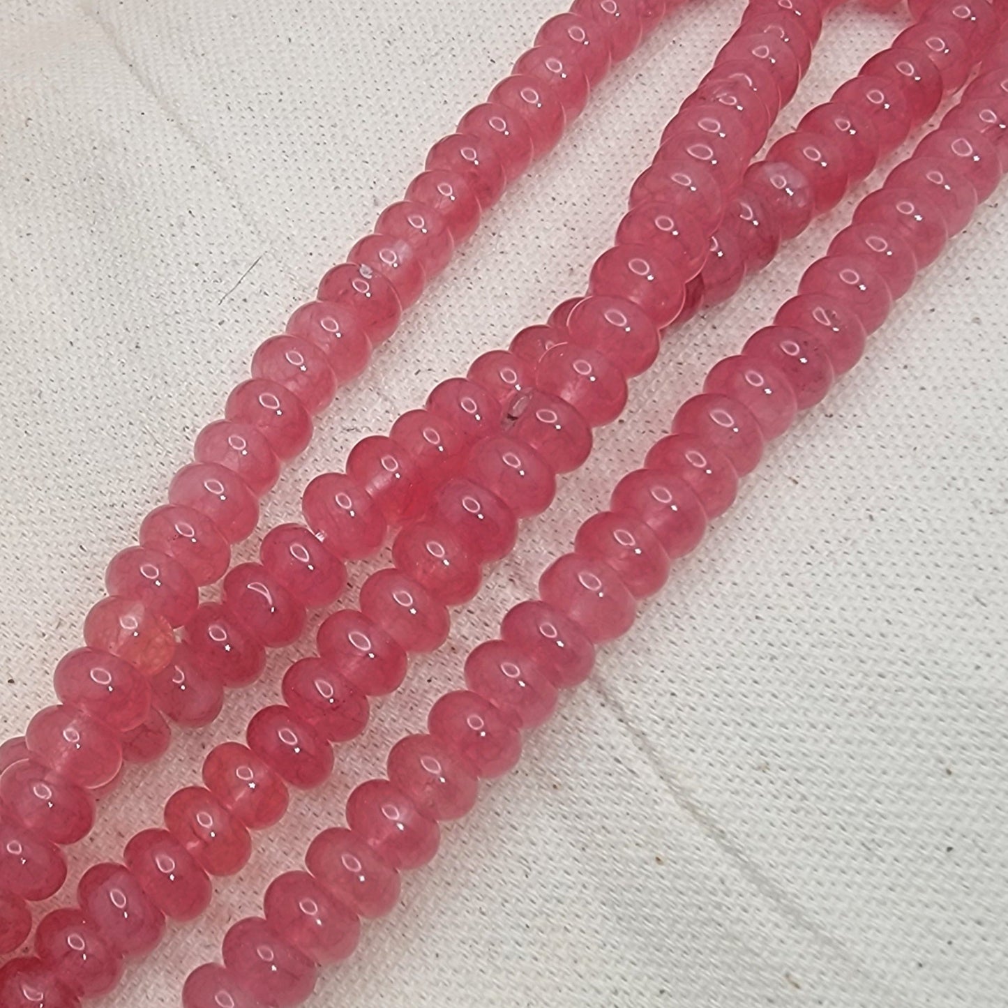 String of pink beads on a textured white background