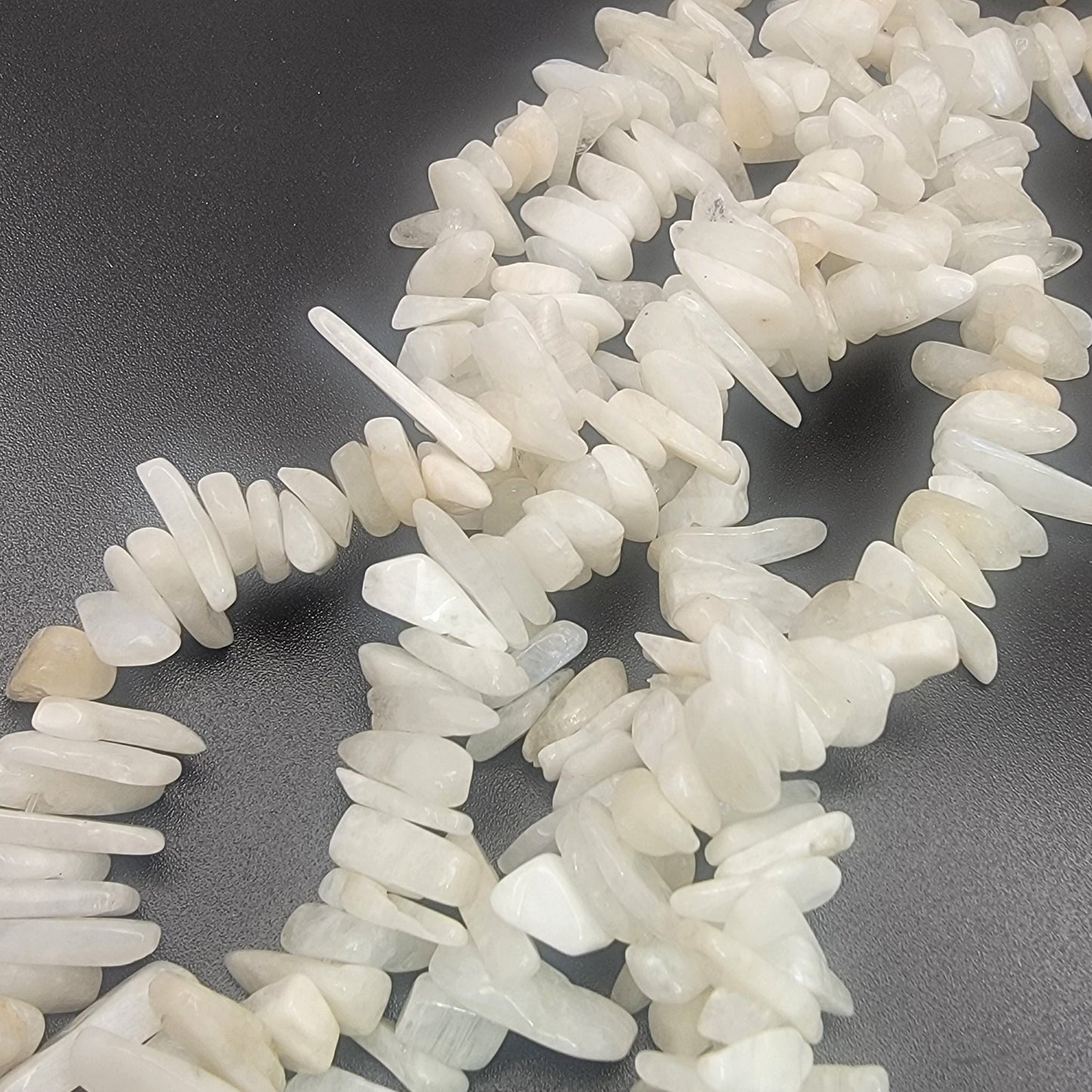 white irregular shaped moonstone gemstone beads on a black backround