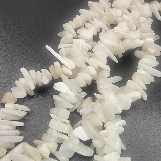 white irregular shaped moonstone gemstone beads on a black backround