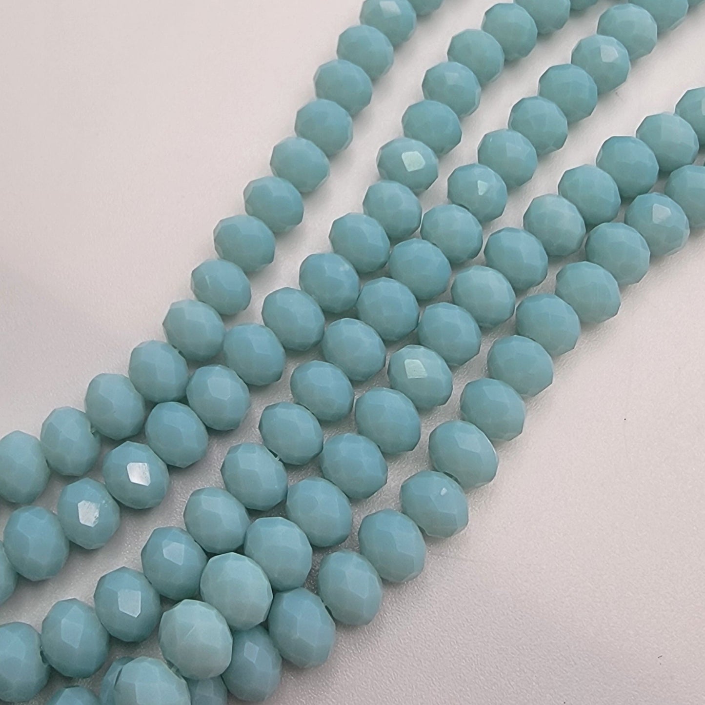 String of light blue beads on a light gray background
