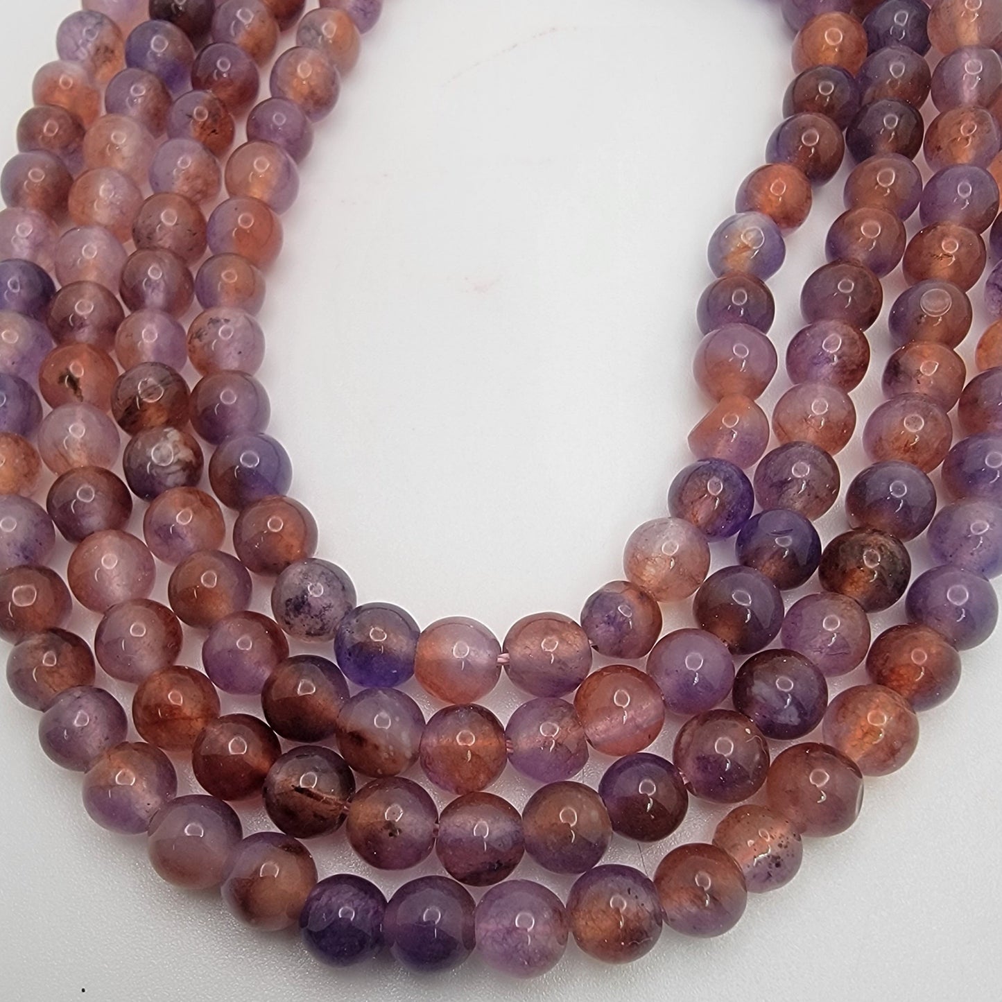 Purple and brown bead strands on white background