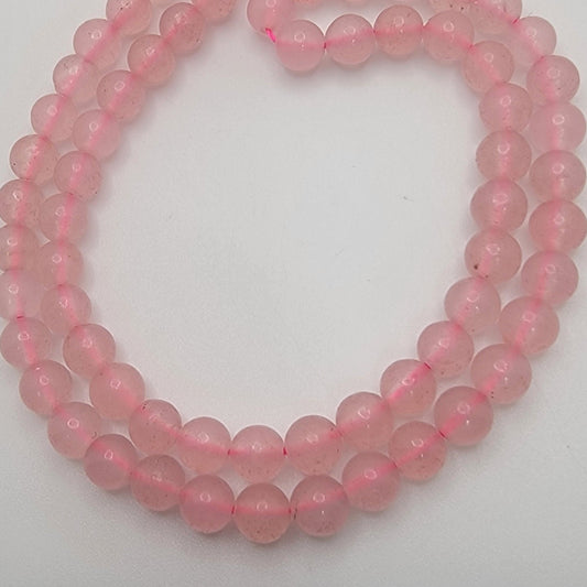 Pink bead strands on a white background