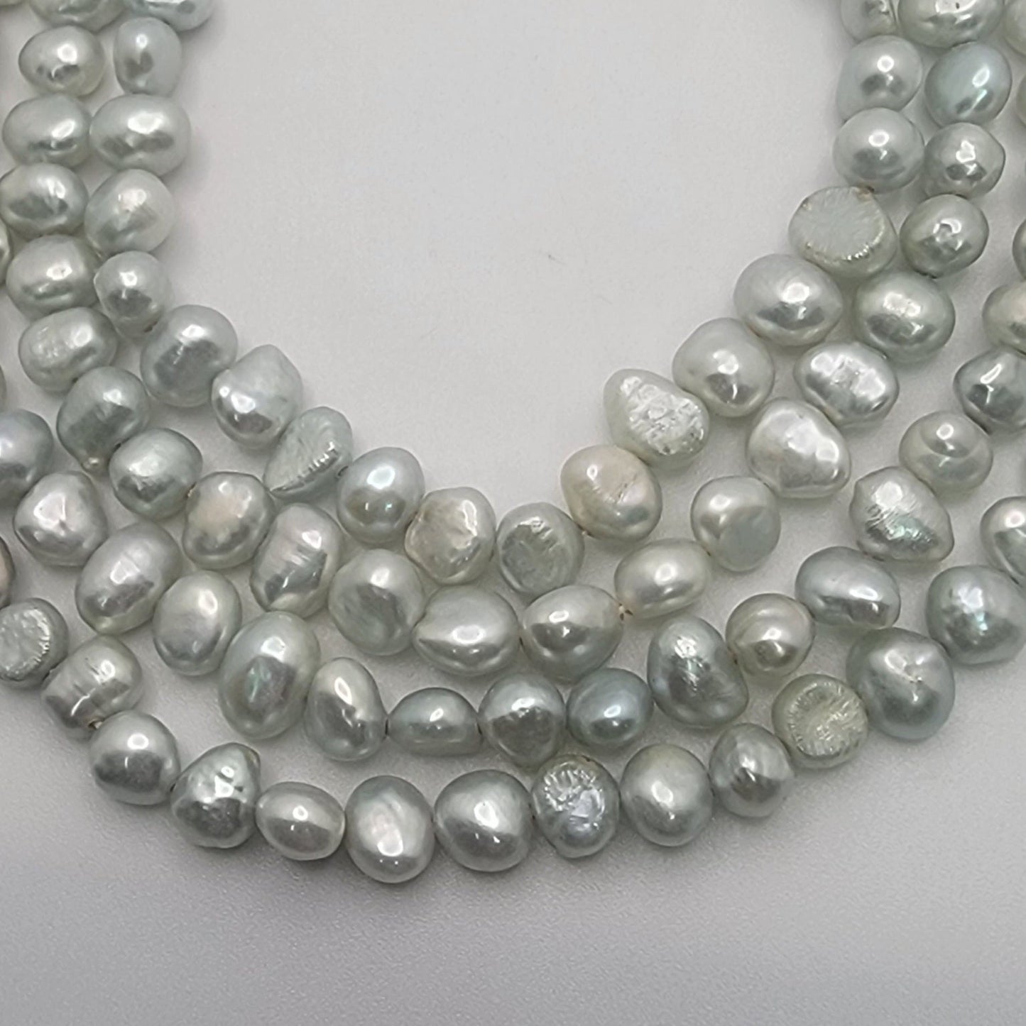 Light blue bead strands on white background
