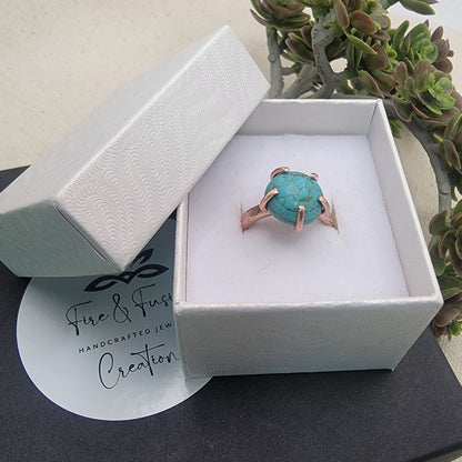 Turquoise ring in a white box with 'Fire & Fusion' branding, on a light background.