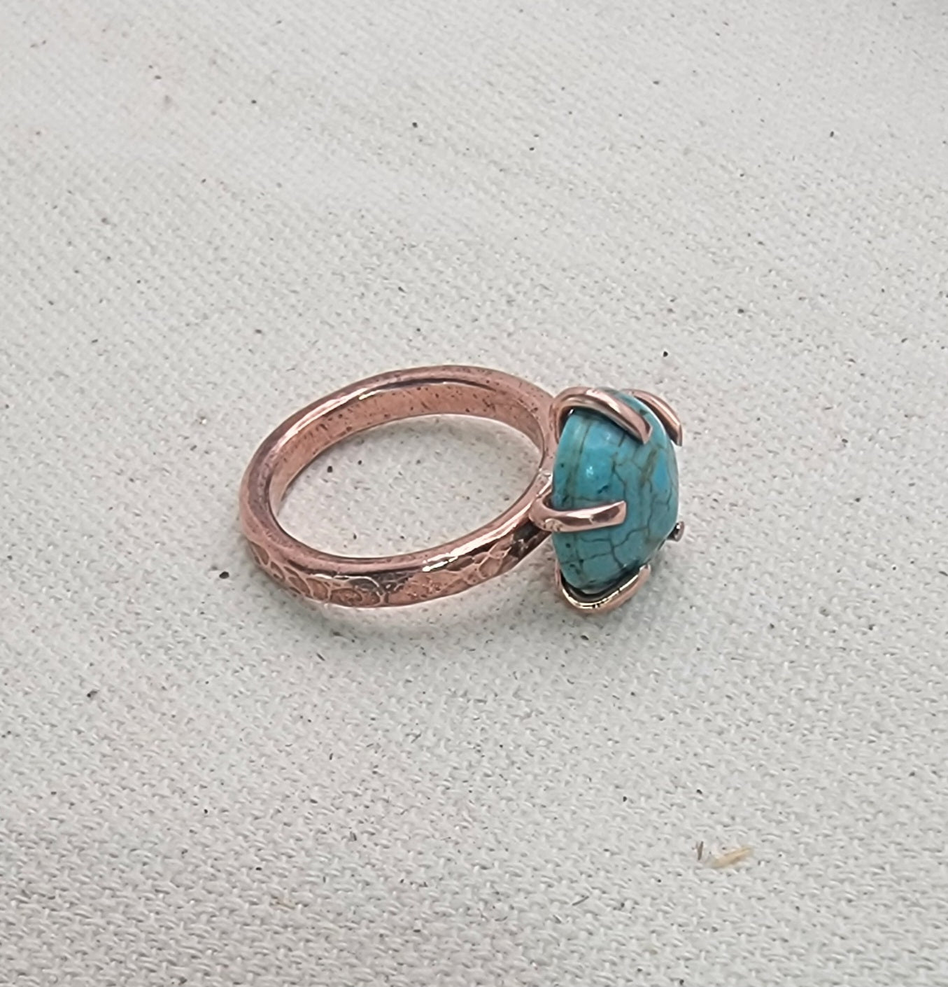 Ring with turquoise stone on a textured gray background