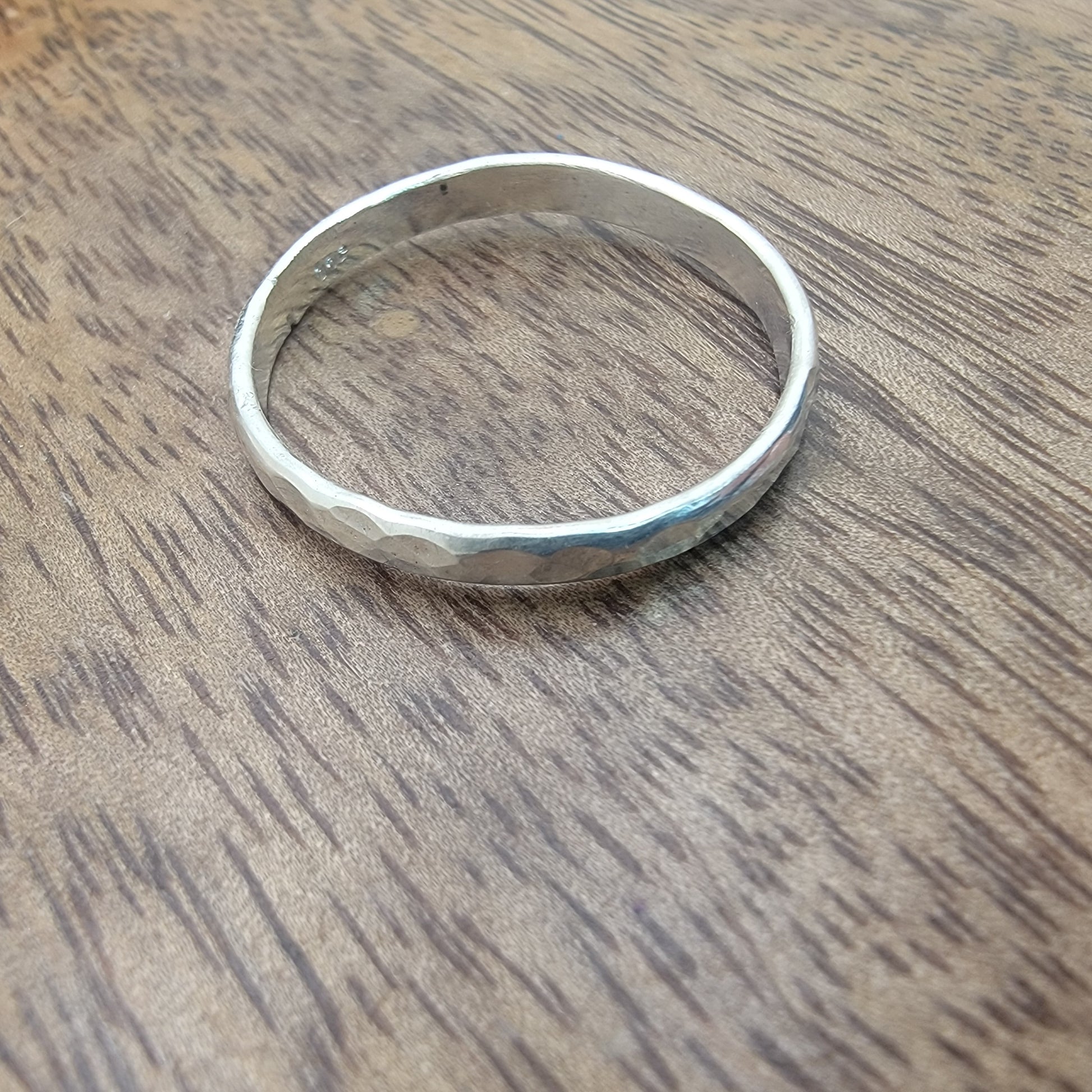 Silver ring on a wooden surface