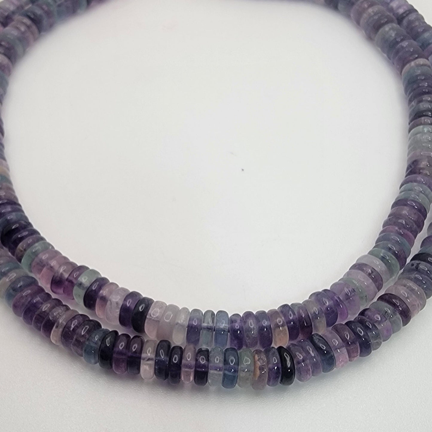 Necklace with purple and black beaded strands on a white background