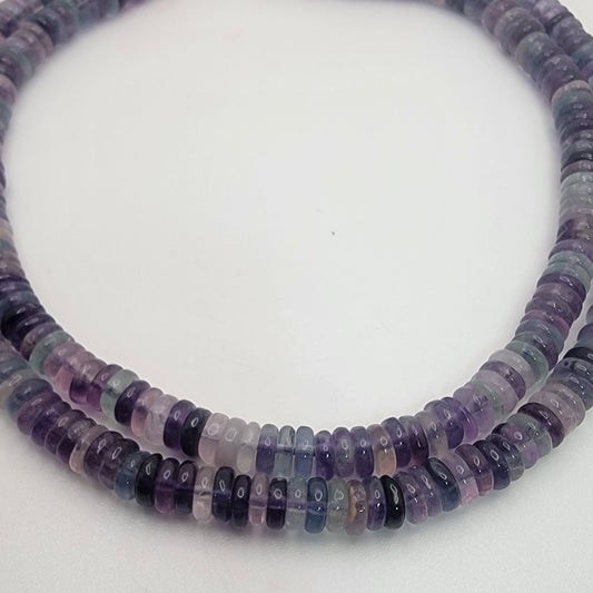 Necklace with purple and black beaded strands on a white background