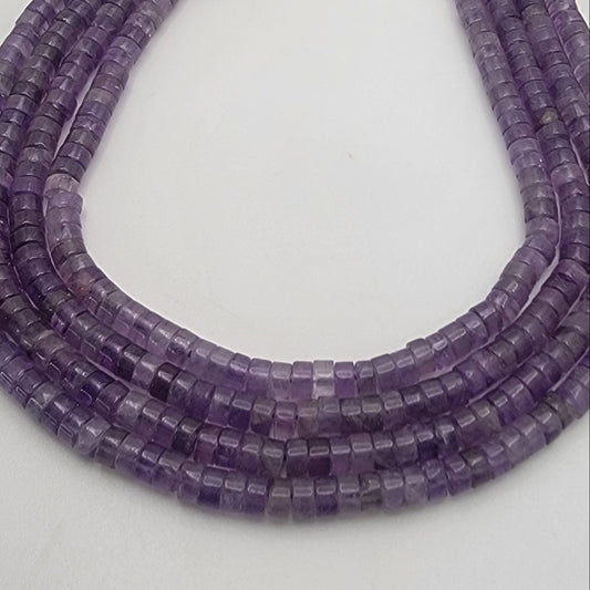Three strands of purple beads on a light gray background