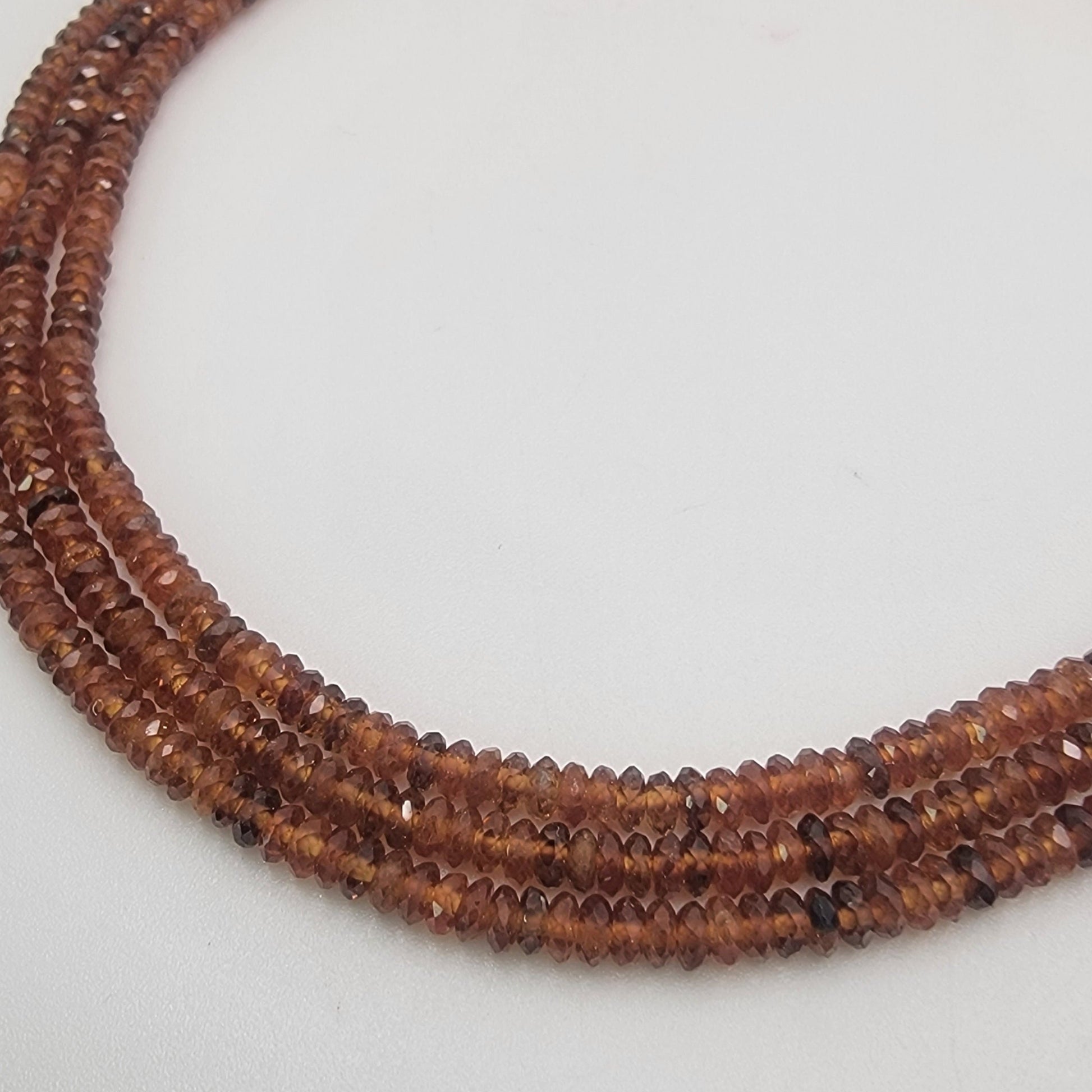 Close-up of a string of brown beads on a light gray background