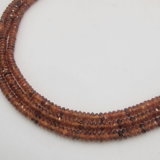 Close-up of a string of brown beads on a light gray background