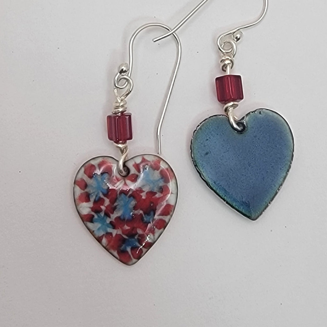 Heart-shaped earrings with floral pattern and solid color on a white background