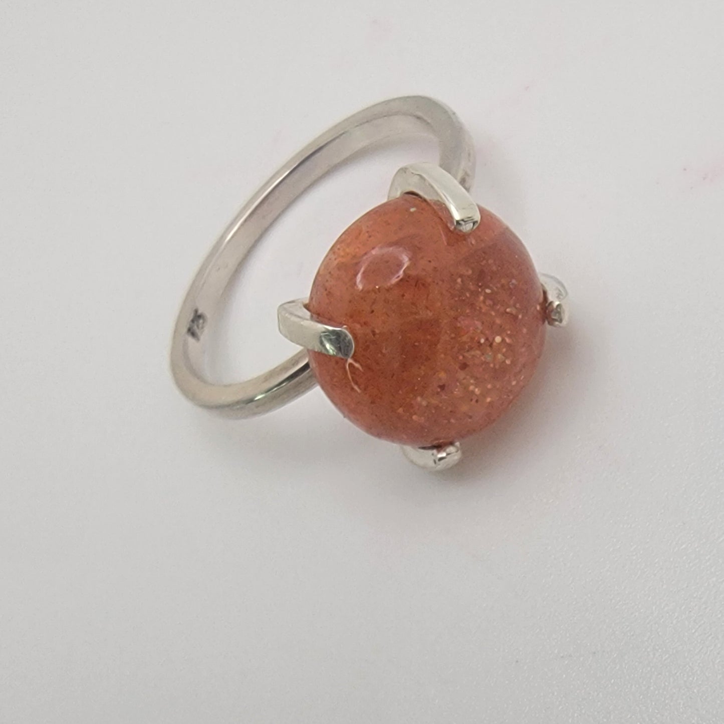 Ring with a brown bead and silver band on a white background