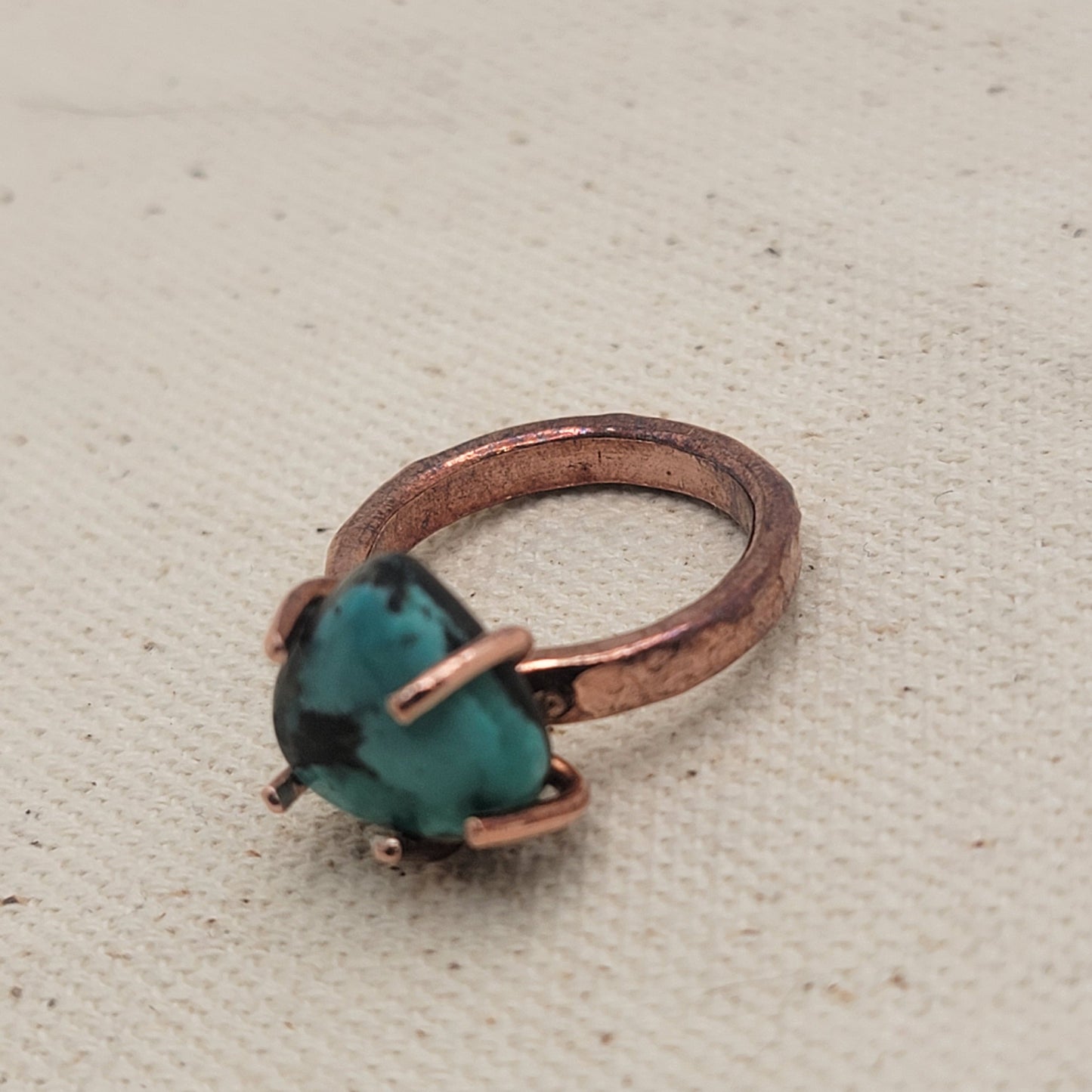 Copper and turquoise ring on beige background