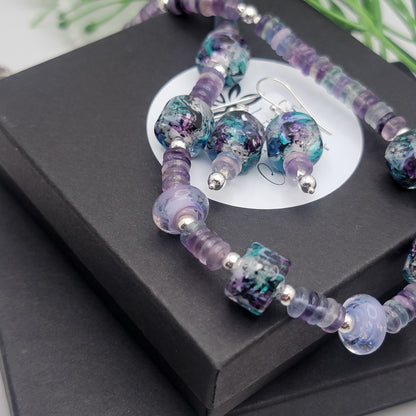 Jewelry set with purple and blue beads on a black box