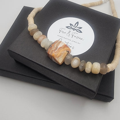 Necklace with agate stones on a black box with 'Fire & Fusion' branding.