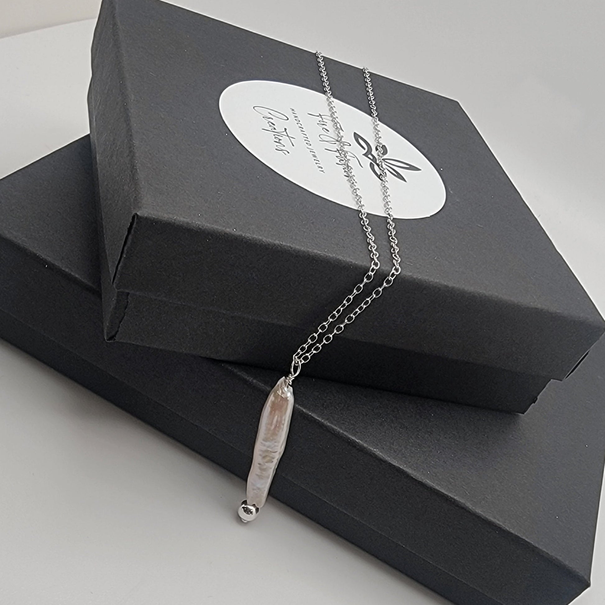 Necklace with a pearl pendant on a black jewelry box