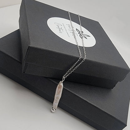 Necklace with a pearl pendant on a black jewelry box