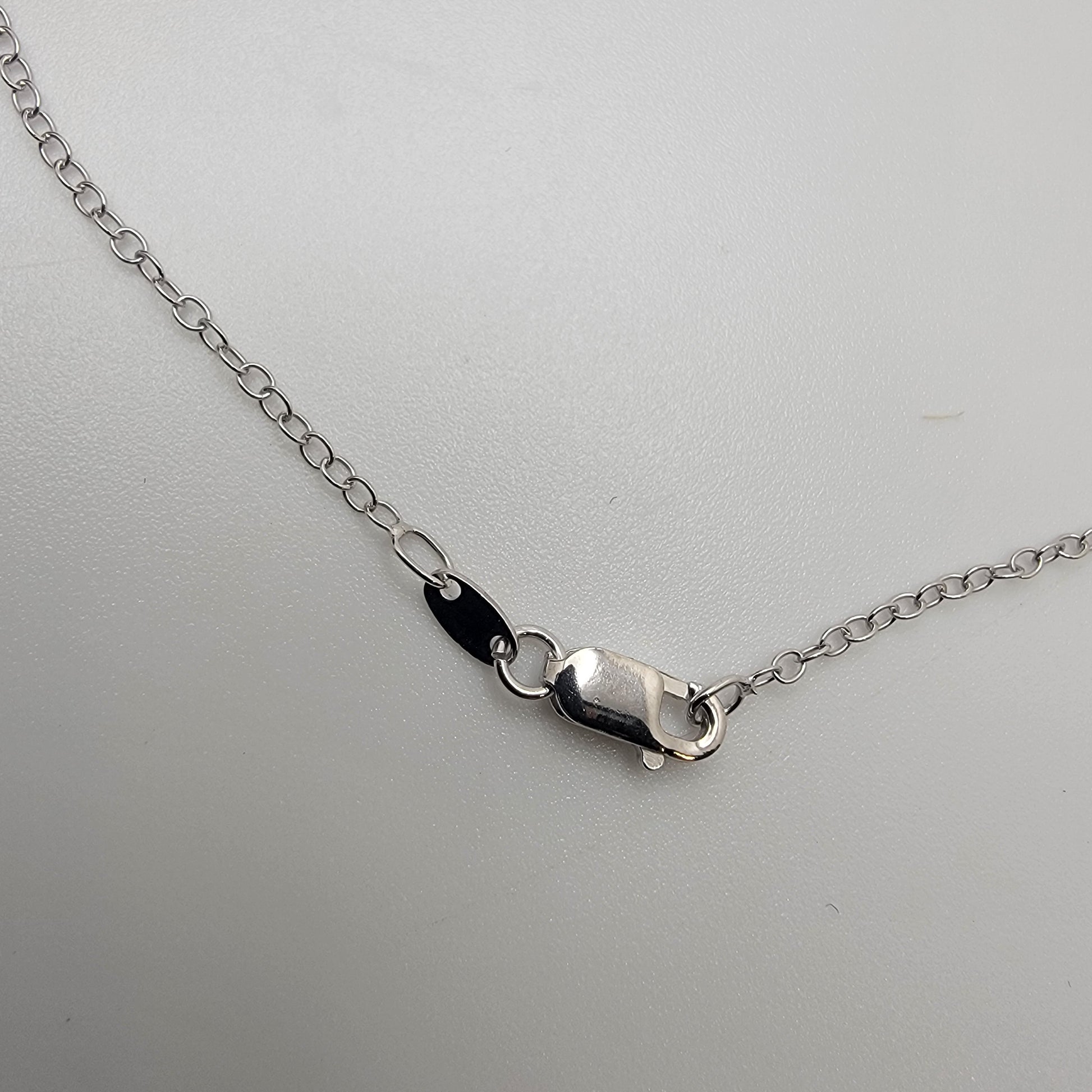 Silver necklace lobster clasp on a light gray background