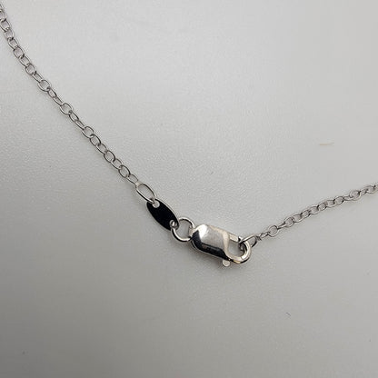 Silver necklace lobster clasp on a light gray background