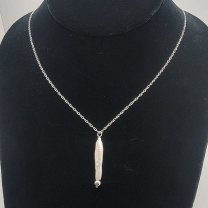 Silver necklace with a pendant on a black bust