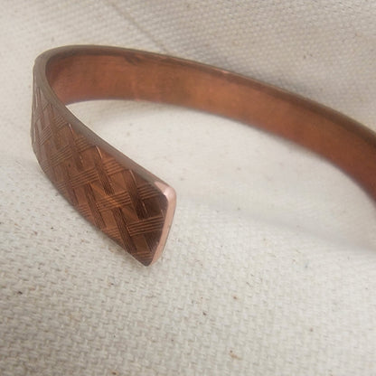 Copper bracelet on a textured beige background