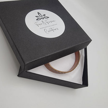 Black jewelry box with a bracelet inside on a white background