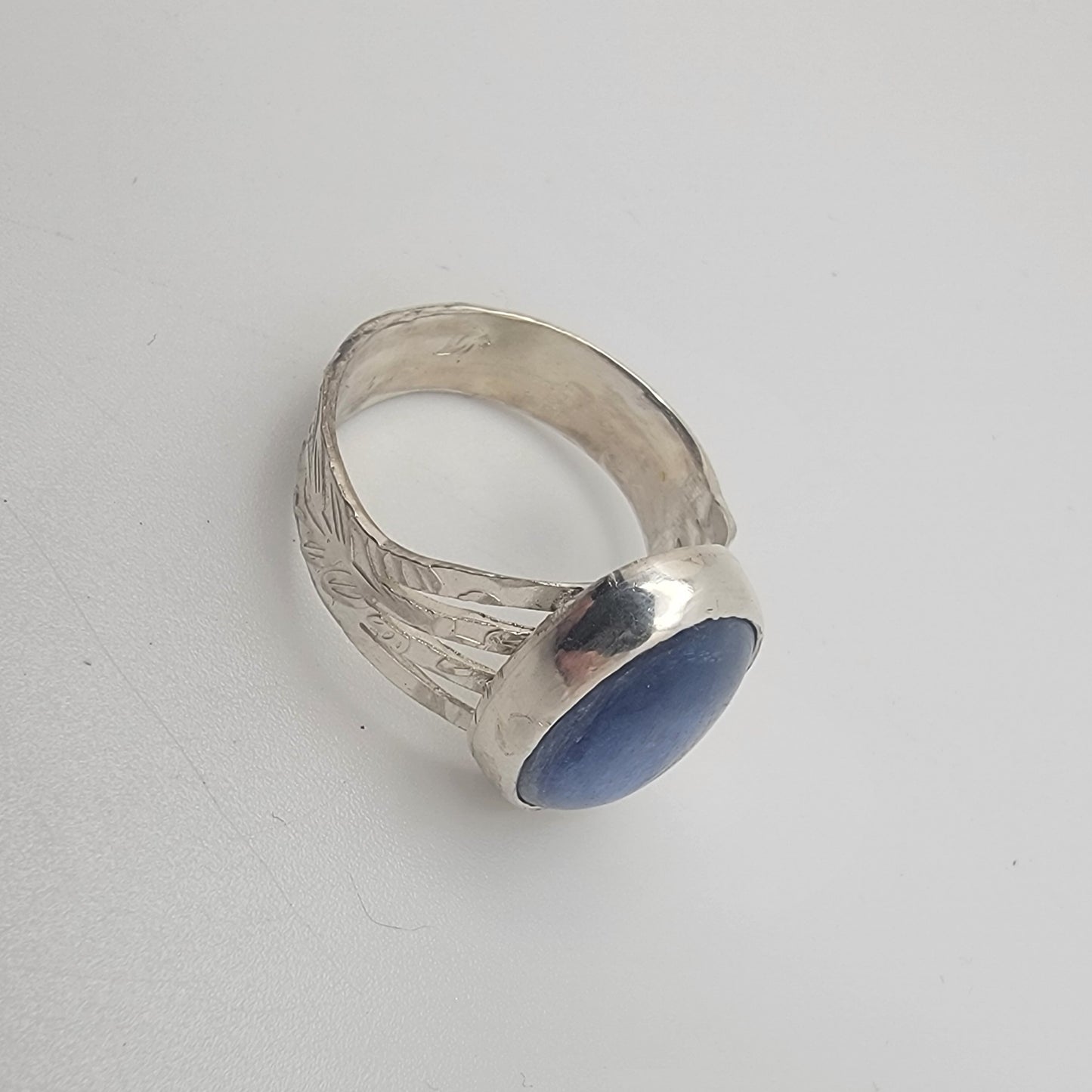 Silver ring with a blue stone on a white background