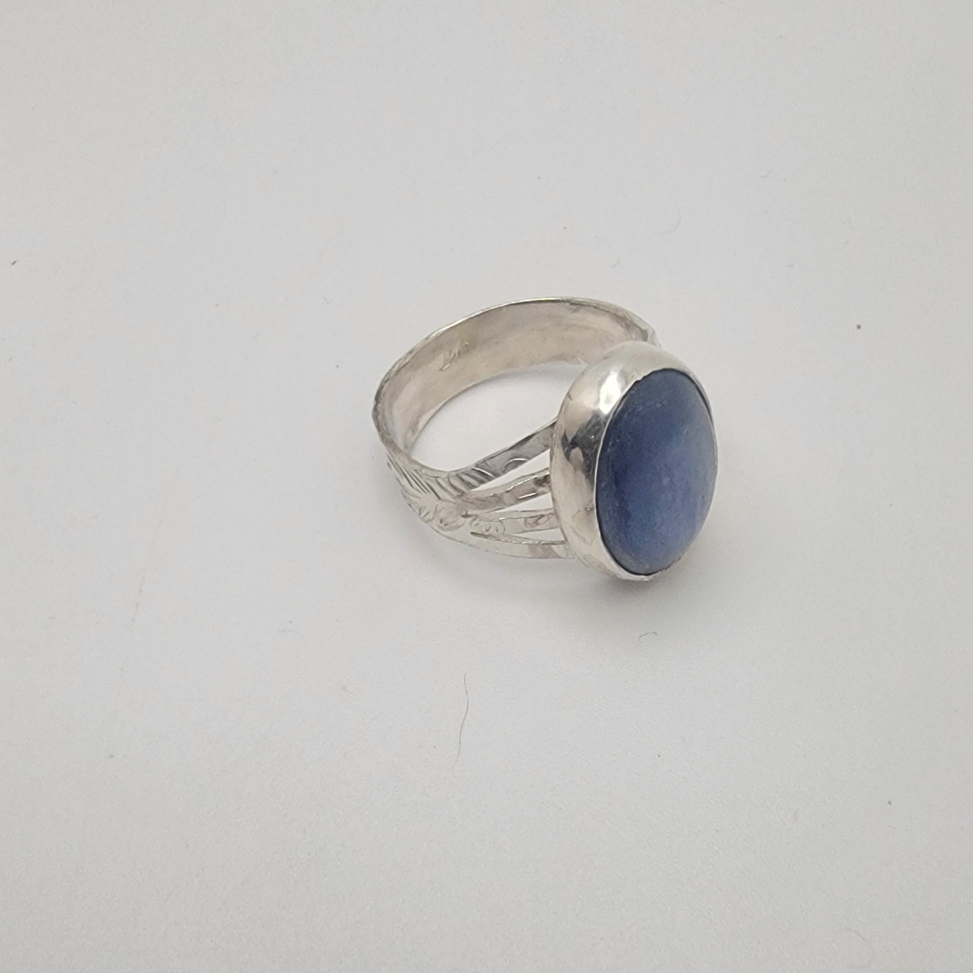 Silver ring with a blue stone on a white background