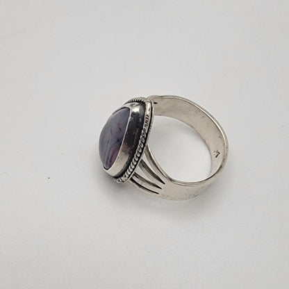 Silver ring with a purple stone on a white background